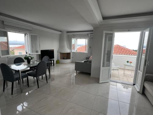 a living room with a table and chairs and a couch at Modern Sea-View Maisonette in Spetses for 6 people in Spetses