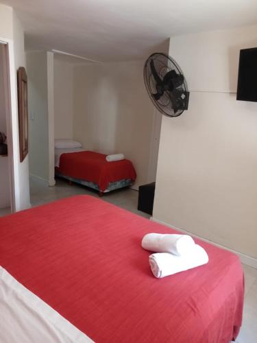 a bedroom with a red bed with towels on it at San Remo Viking Hotel in Pinamar