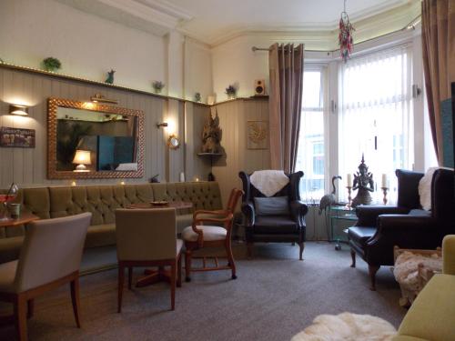 een woonkamer met een bank, stoelen en een spiegel bij The Rockley Hotel in Blackpool