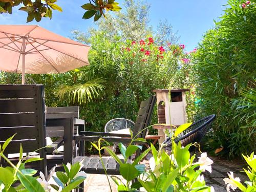 eine Terrasse mit Stühlen, einem Sonnenschirm und Blumen in der Unterkunft Appartamento villatorretta24 in Riva del Garda