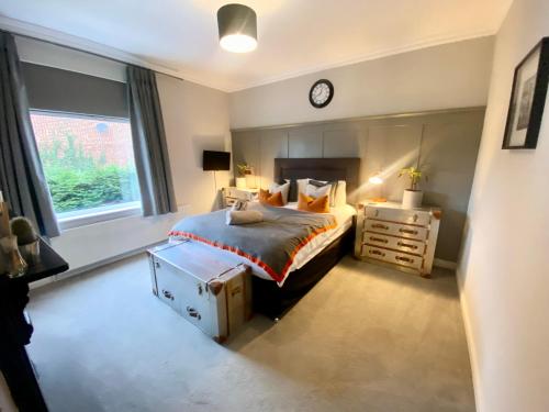 1 dormitorio con 1 cama y reloj en la pared en Interior Designed 4 bed Home Horsforth with gym! en Horsforth