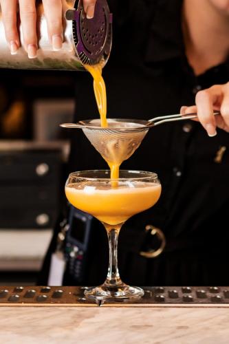 a person pouring a drink into a martini glass at Radisson Blu Hotel, Glasgow in Glasgow
