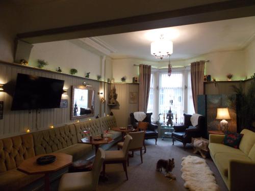 a living room with a couch and a dog in it at The Rockley Hotel in Blackpool