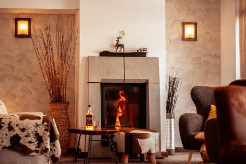 a living room with a fireplace and a table at Hotel Smilen in Smolyan