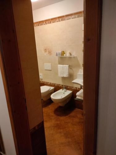 a bathroom with a toilet and a sink at Hotel Stella Alpina in Moena