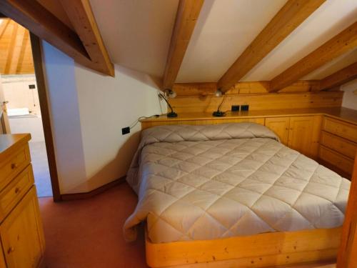 a bedroom with a bed in a room with wooden ceilings at Hotel Stella Alpina in Moena