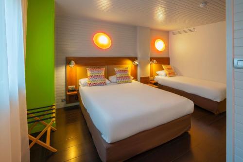 two beds in a room with green and white at Campanile Annecy Centre - Gare in Annecy