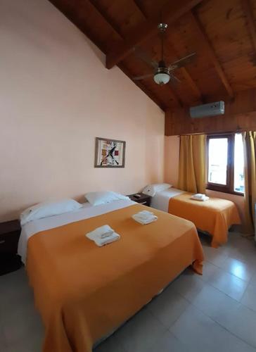 a bedroom with two beds with towels on them at San Remo Viking Hotel in Pinamar