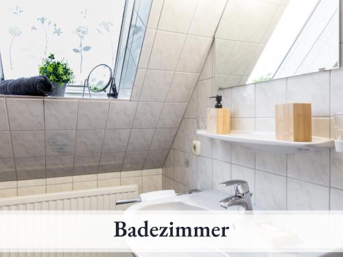 een badkamer met een wastafel en een spiegel bij Blumenvilla 6 mit Küche, Balkon, Sauna und Garten in Schneverdingen