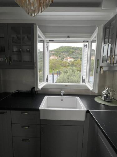 een keuken met een witte wastafel en een raam bij Spetses maisonette 2 bedrooms for 6 persons. in Spetses