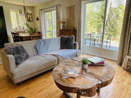 a living room with a couch and a table at Chalet NABU L'Ours - Rivière - Billard in Saint-Alexis-des-Monts