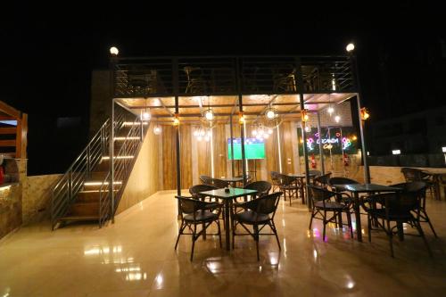 a restaurant with tables and chairs at night at Locanda Pyramids Hotel in Cairo