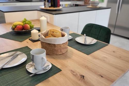 un tavolo con un piatto di pane e un cesto di frutta di Ferienwohnung Domspitzen a Billerbeck