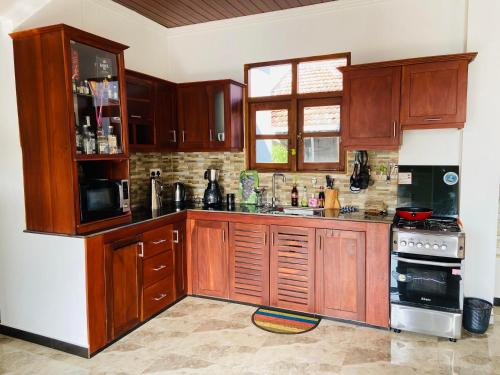 a kitchen with wooden cabinets and a stove at Erin Orr Villa in Wadduwa