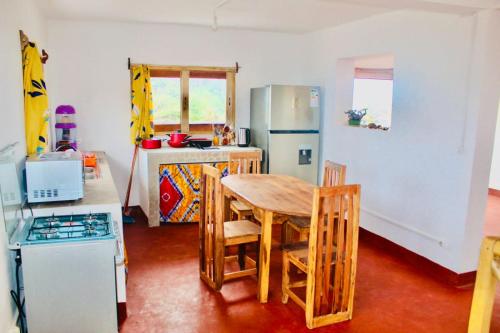 eine Küche mit einem Tisch und Stühlen sowie einem Kühlschrank in der Unterkunft Villa Baobab in Tôlagnaro
