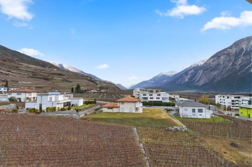 a small town with mountains in the background at Appartement au coeur du vignoble in Salgesch