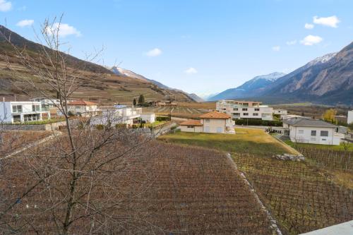 a view of a village with mountains in the background at Appartement au coeur du vignoble in Salgesch