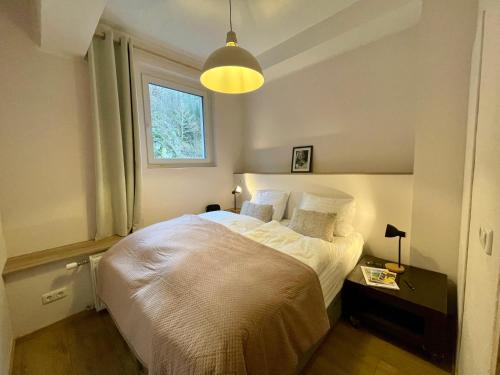 a bedroom with a white bed with a window at Äuchen am Rosenthal in Monschau