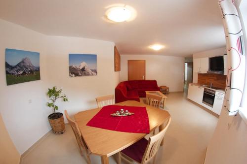 a living room with a table and a red couch at Ferienwohnung Radmer in Radmer an der Hasel