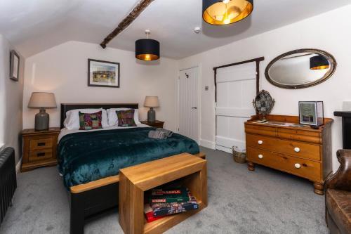 a bedroom with a bed and a dresser and a mirror at The Clockhouse Bewdley in Bewdley