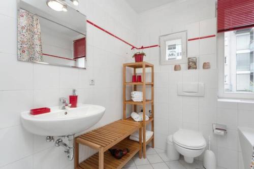 a white bathroom with a sink and a toilet at City Apartment Dresden in Dresden