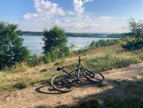 a bike parked on a dirt road next to a lake at KuK Račice in Račice
