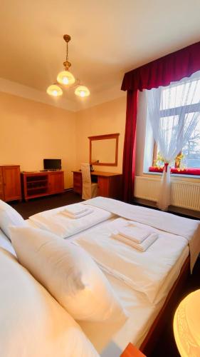a bedroom with two beds and a window at Penzion Černý Kůň in Hradec Králové