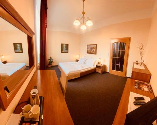 a hotel room with two beds and a chandelier at Penzion Černý Kůň in Hradec Králové
