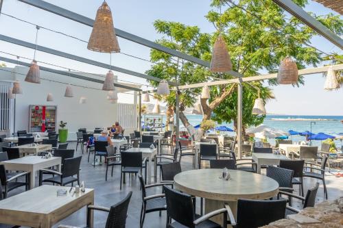 a restaurant with tables and chairs and the beach at Lido Star in Faliraki