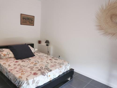 1 dormitorio con 1 cama en una habitación blanca en La verdine, en Arles