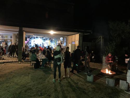 a group of people standing around a fire at night at KuK Račice in Račice