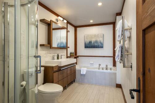 a bathroom with a toilet and a sink and a tub at Altitude 172-8/On Village with Astonishing VIEWS in Mont-Tremblant