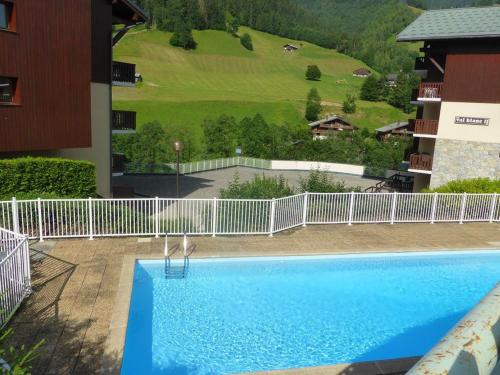 une grande piscine bleue à côté d'un immeuble dans l'établissement Appartement 5 pers. avec piscine, balcon, proche ski et village - FR-1-342-215, à Beaufort