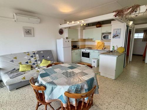une cuisine et une salle à manger avec une table et un canapé dans l'établissement Appt 2 pièces 4 pers climatisé avec balcon, parking et animaux admis à 150m de la plage - FR-1-229C-46, à Port-la-Nouvelle