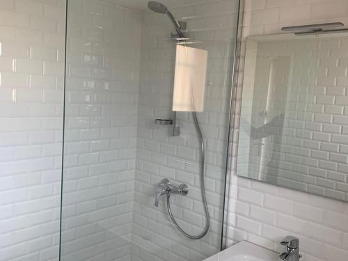 une salle de bain avec une douche avec une porte vitrée dans l'établissement Appartement Climatisé 2 Pièces avec Terrasse et Parking - Classé 2 Étoiles - FR-1-326-690, à Marseillan
