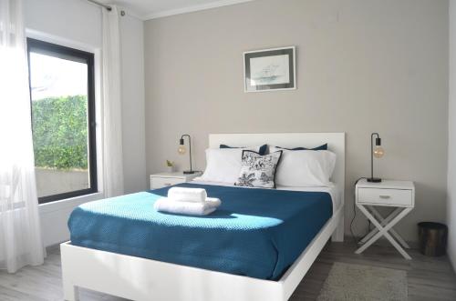 a bedroom with a blue and white bed with a window at House Seven in Horta