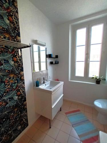 une salle de bain avec un lavabo et des toilettes et une fenêtre dans l'établissement Le Relais du Fraysse - Chambres d'hôtes, à Le Fraysse