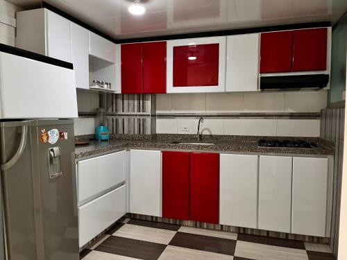 a kitchen with red and white cabinets and a refrigerator at Confort 401 Apartamento Duitama in Duitama