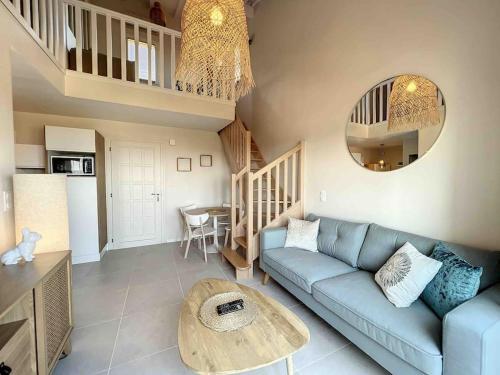 un salon avec un canapé bleu et une table dans l'établissement Monticello duplex vue exceptionnelle mer et montagne, à Monticello