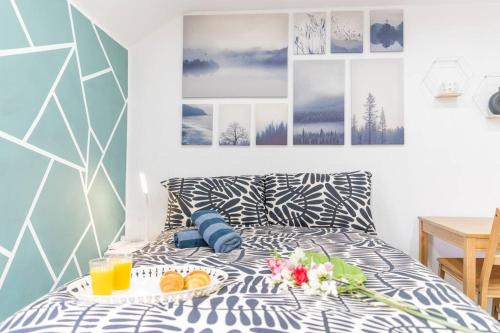 a bed with a tray of food and two glasses of orange juice at Stylish Studio in Moseley Village in Birmingham