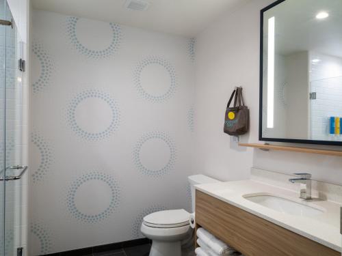 a bathroom with a toilet and a sink and a mirror at Tru By Hilton Atlanta Airport College Park in Atlanta