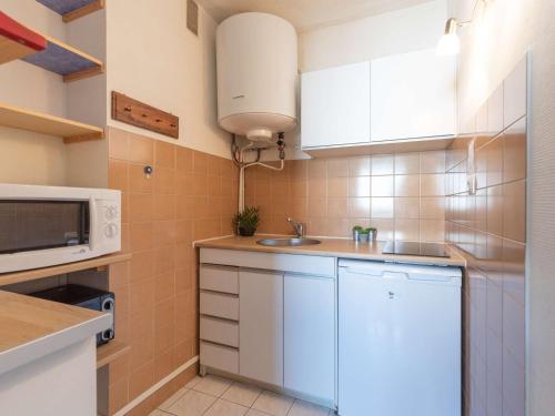 une petite cuisine avec un évier et un micro-ondes dans l'établissement Studio 4 pers - Pla d'Adet - Proche piste & téléphérique - FR-1-296-311, à Saint-Lary-Soulan