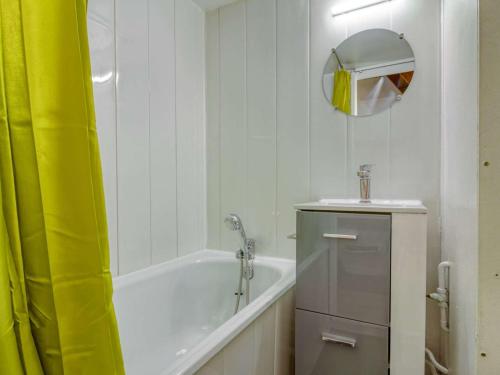 une salle de bain avec une baignoire, un lavabo et un miroir dans l'établissement Charmant Duplex 18m² à 150m des Pistes, Centre Cauterets, Parking Gratuit - FR-1-401-195, à Cauterets
