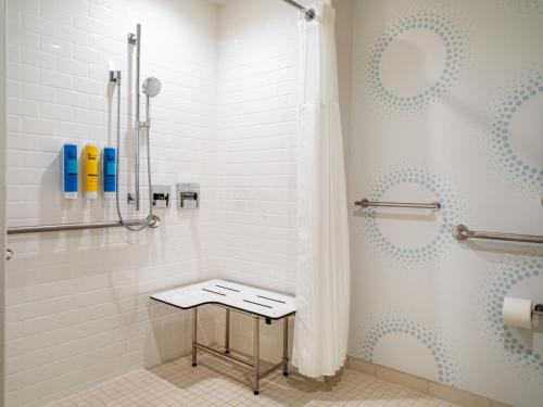 a bathroom with a shower with a stool in it at Tru By Hilton Atlanta Airport College Park in Atlanta