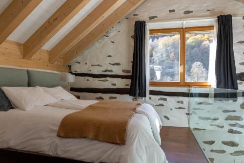 Verzasca Lodge Ofelia في Sonogno: غرفة نوم بسرير كبير ونافذة