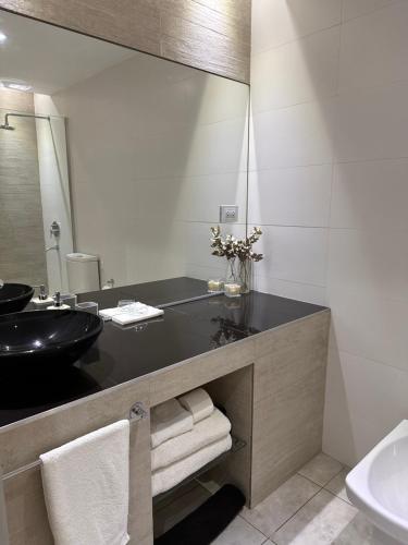 baño con lavabo negro y espejo en Loft & Wines en Maipú
