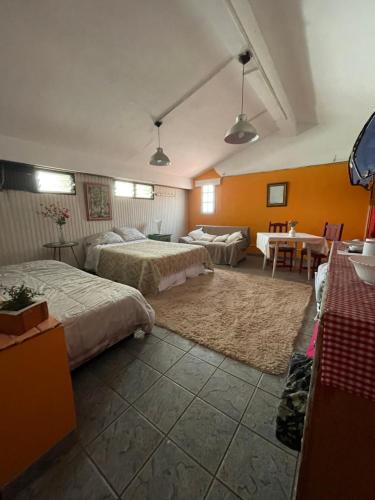 una camera d'albergo con due letti e un tavolo di Habitación privada Barrio Uno a Ezeiza