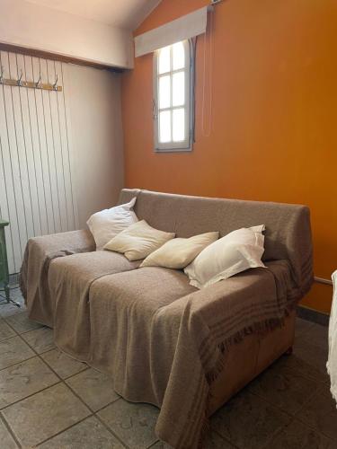 un sofá con almohadas en una habitación en Habitación privada Barrio Uno en Ezeiza