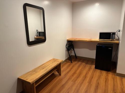 a mirror on a wall with a table and a bench at Motel 6 Sullivan MO in Sullivan