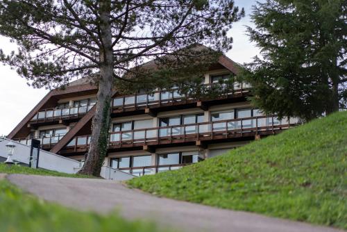 a building on a hill with a tree in front of it at Village Vacances Cap France La Bolle in Saint Die